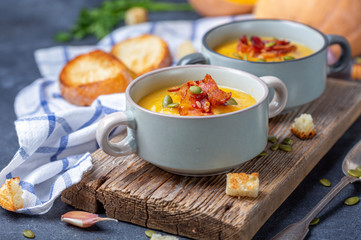 Pumpkin soup with bacon in a rustic style.
