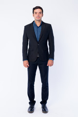 Full body shot of young handsome Persian businessman in suit