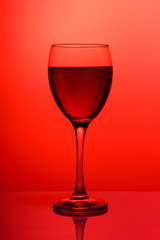 Wineglass with red wine close-up isolated on coral gradient background