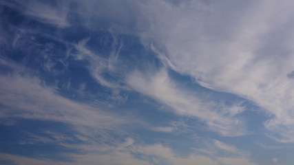 feathery, wavy, fluffy clouds in the blue sky