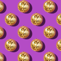 New year baubles. Shiny gold disco balls on violet background. Pop disco style attributes, retro concept. Creative Christmas pattern. Flat lay, top view.
