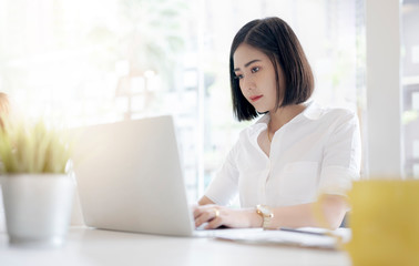 Portrait of young businesswoman working with laptop in modern office.