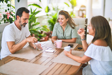 Beautiful family sitting on terrace drinking cup of coffee speaking and smiling