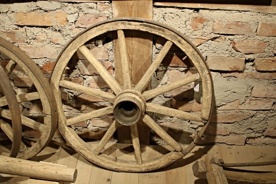 Old wooden wheels from grandfather's cart are stored in a rustic barn