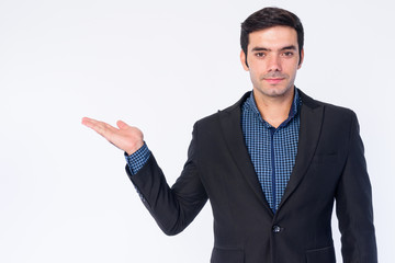 Portrait of young handsome Persian businessman in suit showing something