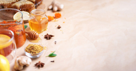 Autumn harvest concept. Set of honey and bee products, apple, lemon, spices on craft paper background. Immune system support with alternative medicine