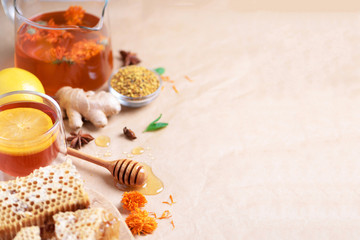 Fototapeta na wymiar Alternative medicine concept. Ingredients for flu fighting natural hot drink. Copy space. Lemon, ginger, mint, honey, apple and spices on craft paper background