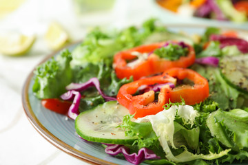 Fresh salad in plate on light background, close up