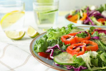 Fresh salad in plate on light background, close up