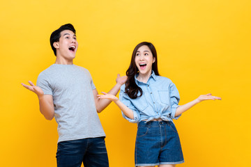 Excited young couple in casual clothing gesturing wow - obrazy, fototapety, plakaty