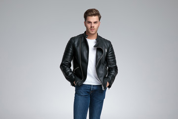 casual man standing with hands in pockets and looking ahead