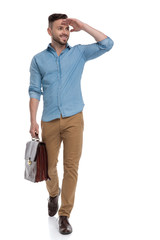 casual man walking with briefcase and hand on forehead