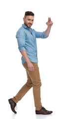 Fototapeta premium casual man walking and looking at camera with peace sign