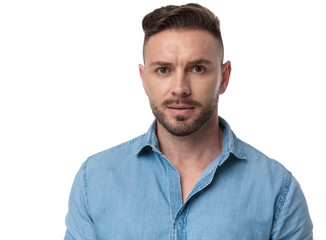 casual man standing and looking at camera serious