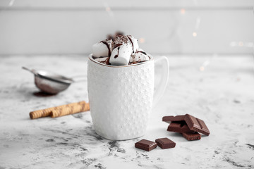 Cup of hot chocolate with marshmallows on white table