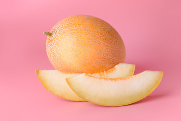 Sweet ripe melon and slices on color background