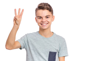 Portrait of happy teen boy showing one palm - 3 fingers, isolated on white background. Happy...