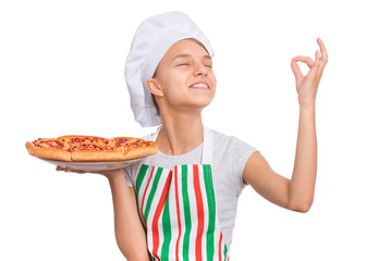 Happy teen girl in chef hat holding cooked pizza and showing sign for delicious. Girl cook in apron holds plate with fresh pizza, isolated on white background. Portrait of child with perfect sign.