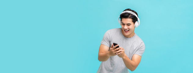 Smiling Asian man wearing wireless headphones listening to music