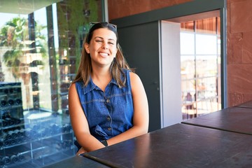 Young beautiful woman sitting at restaurant enjoying summer vacation