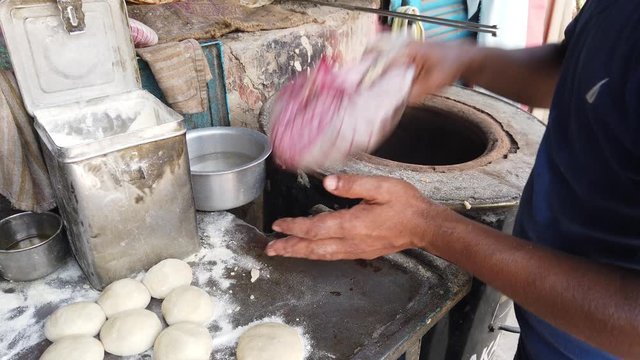 Preparation of traditional Tandoori Roti, a round flatbread native to the Indian subcontinent made from stoneground wholemeal flour or atta. Water is combined with dough. Popular over South east Asia