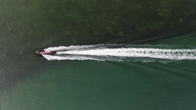 4K Aerial Drone Footage of a motor boat cruising through the ocean in Thailand