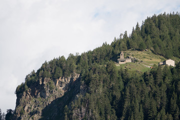 Naklejka premium church/chapel close to cliff drop-off above mountain valley