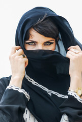 Portrait of an arabic young woman with her beautiful blue eyes in traditional middle eastern dress.