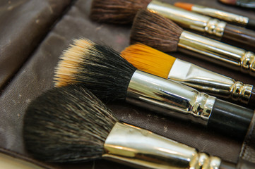 Cosmetics and beauty concept. Make-up brushes on holster.