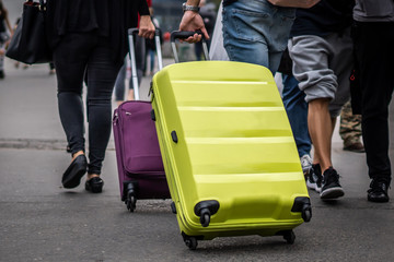 Travellers dragging luggages on the street in the city centre. 