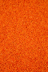 Red lentils texture, side view. Close-up.