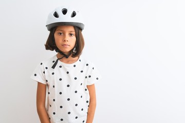 Beautiful child girl wearing security bike helmet standing over isolated white background Relaxed with serious expression on face. Simple and natural looking at the camera.