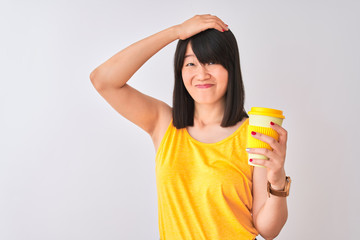 Young beautiful Chinese woman drinking take away coffee over isolated white background stressed with hand on head, shocked with shame and surprise face, angry and frustrated