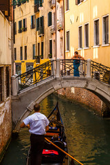 Fototapeta na wymiar Beautiful girl in a blue dress is standing on the bridge in Venice. Europe travel vacation.