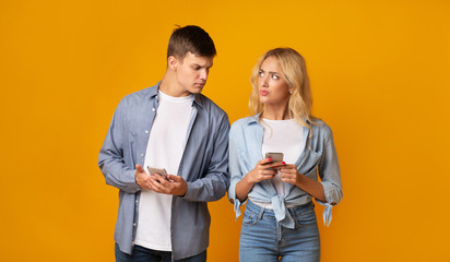 Jealous guy looking at girlfriend's cellphone, reading her messages