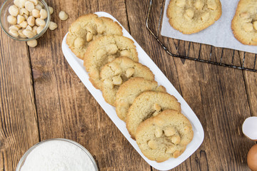 Old wooden table with fresh Macadamia Cookies (close-up shot; selective focus)