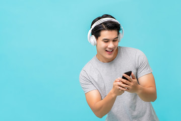 Smiling Asian man wearing wireless headphones listening to music