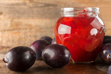 Preservation of freshly picked plums on a rustic wooden background