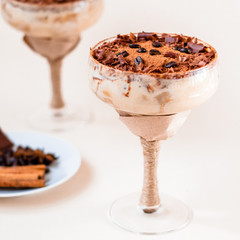italian dessert tiramisu in an elegant cocktail glass, the concept of sweet life, luxury, delicious food
