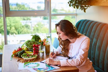 Woman dietitian in medical uniform with tape measure working on a diet plan sitting with different...