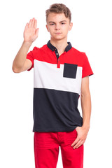 Teen boy doing stop sign with palm of hand, isolated on white background. Beautiful caucasian teenager making stop gesture with negative and serious facial expression. Angry child looking at camera.