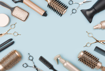 Fototapeta na wymiar Professional hairdressing tools and accessories on blue background with space