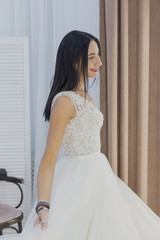 Beautiful girl tries on a wedding dress in a bridal salon.