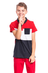 Teen boy asking to be quiet with finger on lips, isolated on white background. Cute young teenager making keep Quiet gesture. Child asking for silence or secrecy with finger on lips shh sign symbol.