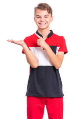 Portrait of happy teen boy pointing finger away at copyspace, isolated on white background. Teenager pointing finger at something. Cute smiling child looking at camera.