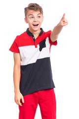 Portrait of surprised teen boy pointing finger away at copyspace, isolated on white background. Teenager pointing finger at something. Cute amazed child looking away.