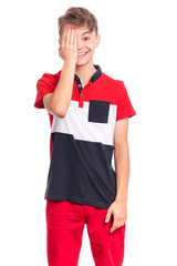 Portrait of happy teen boy covering one eye with hand checking eyesight. Human facial positive emotion. Smiling child isolated on white background. Health examinations. Teenager looking at camera.