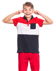 Silly teen boy making grimace - funny monkey face. Child with big ears, isolated on white background. Emotional portrait of teenager looking at camera. Attractive boy stretching ears imitating monkey.
