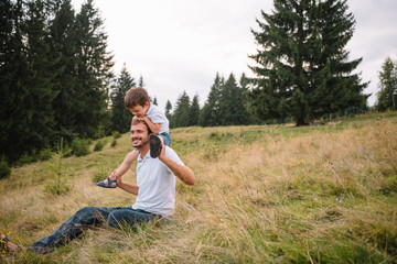 Father and child hiking in scenic mountains. Dad and son enjoying the view from the mountain top in Carpathian mountains