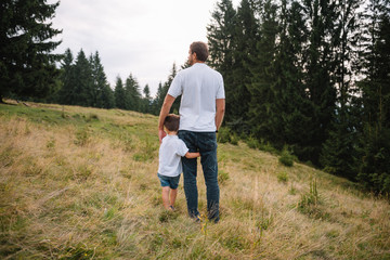 Father and child hiking in scenic mountains. Dad and son enjoying the view from the mountain top in Carpathian mountains